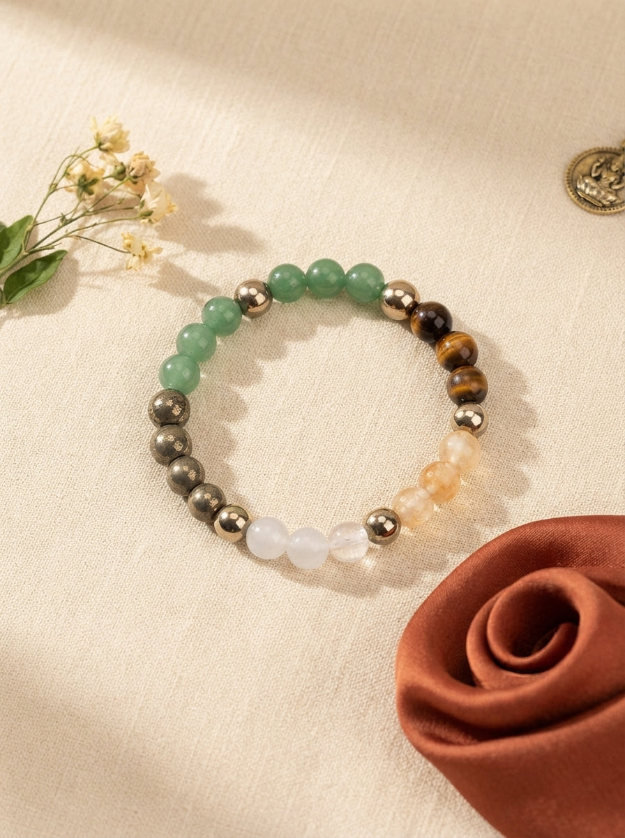 Dhan Yog gemstone bracelet with Tiger Eye, Pyrite, and Citrine beads displayed on a cream linen background.